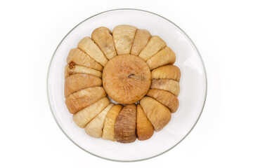 Dried figs laid by circle on glass saucer, top view