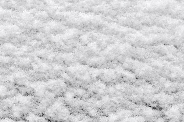 Texture of fluffy snow layer on a vertical dark surface