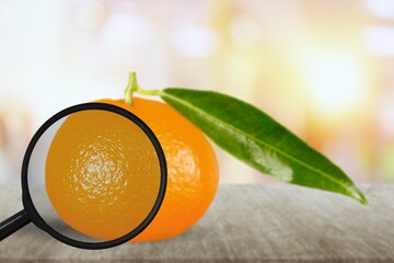 Fresh orange under a magnifying glass. Anti-cellulite creative concept.