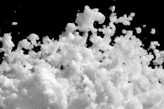White soap foam on a black background. Fun foam, background or texture of white foam with copy space. Entertaining foam parties of the summer entertainment festival in the water park.