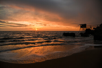 .French oceanfront landscape, oceanfront fishing houses in France during sunset.