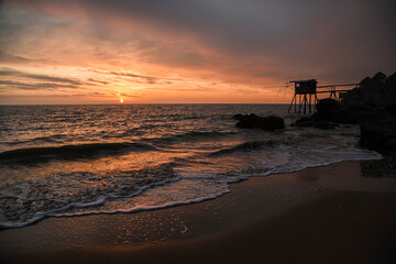 .French oceanfront landscape, oceanfront fishing houses in France during sunset.