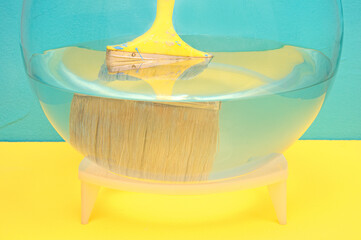 yellow construction brush in an aquarium with water. blue background.