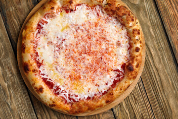Pizza Margherita on wooden background, top view. Flyer and poster for Restaurants or pizzerias, template with delicious taste margarita pizza, mozzarella cheese