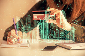 Multi exposure of woman on-line shopping holding a credit card and construction drawing. e-commerce concept.