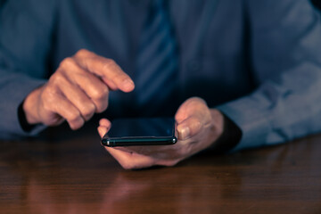 Businessman hand holding mobile phone.