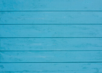 Old weathered wooden plank painted in turquoise blue color. Vintage beach wood background.