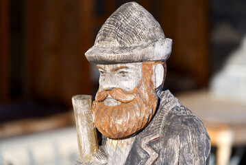 Close-up of sculpture of wooden peasant at playground of restaurant at Winteregg Mürren on a sunny winter day. Photo taken January 15th, 2022, Lauterbrunnen, Switzerland.