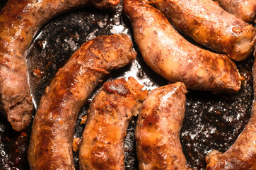 Fried homemade sausages in a frying pan