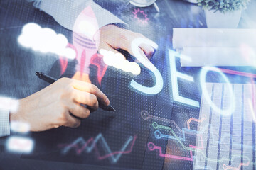 Multi exposure of man's hands holding and using a digital device and seo drawing. search...