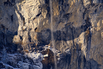 Famous Staubbach Fall at mountain village Lauterbrunnen at Bernese Highlands at the Swiss Alps on a sunny winter day. Photo taken January 15th, 2022, Lauterbrunnen, Switzerland.