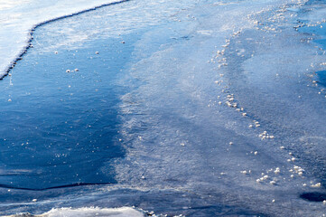 Blue ice texture. Frozen lake shore water for background