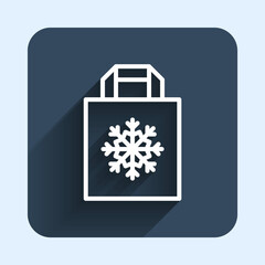 White line Christmas paper shopping bag with snowflake icon isolated with long shadow background. Package sign. Merry Christmas and Happy New Year. Blue square button. Vector