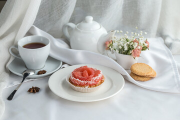 Citrus tartelettes dessert with cream and grapefruit with cup of tea on the table