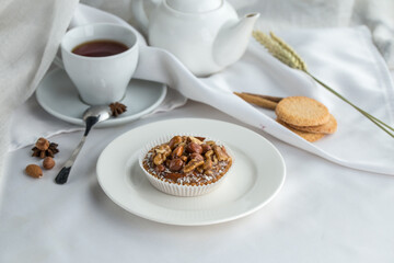 tartelette dessert with salted caramel and hazelnuts and cup of tea on the table