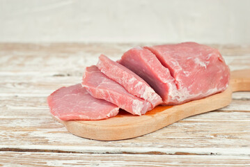 Raw steak on a wooden board. Meat on a white wooden background. Food on an old shabby table.