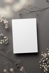 Wedding invitation card mockup with dry flowers twigs on grey