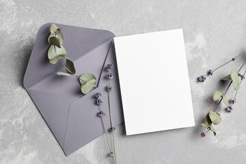 Greeting or wedding invitation card mockup with envelope, dry lavender and eucalyptus twigs