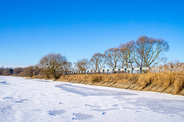 Beautiful view of the dam with trees on a winter sunny day