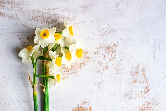 Overhead view of narcissus flowers on a  weathered table