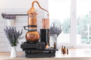 Distillation of lavender essential oil. Copper alambic in a Scandinavian interior. Chemical laboratory - obrazy, fototapety, plakaty