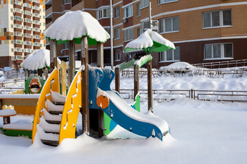 Playground in the snow, slide with stairs covered with snow, unexpected large amount of snow