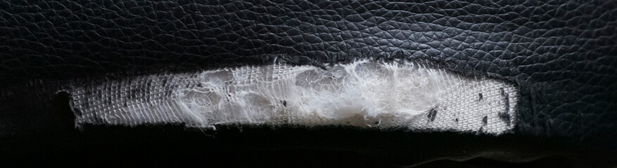 Torn leather upholstery of the chair close-up