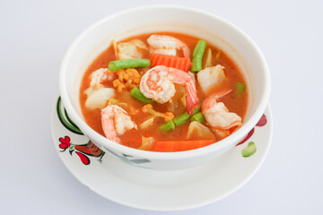 Thai sour shrimps curry with vegetables on white background.