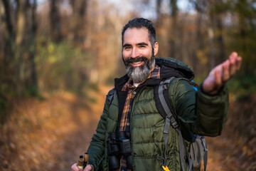 Image of hiker showing invitation gesture while hiking in nature.