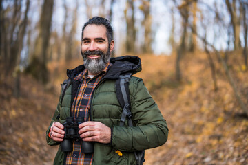Obraz premium Image of man hiking and using binoculars. 