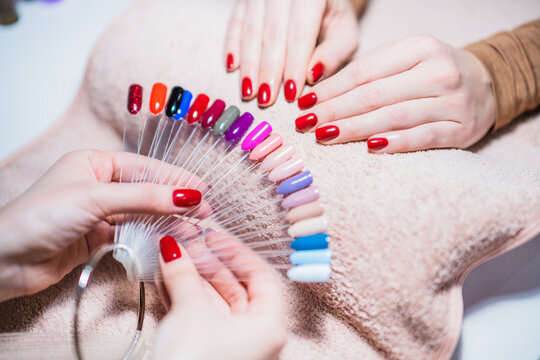 Close up image of manicurist showing  color palette of nail services. Focus on part of palette.