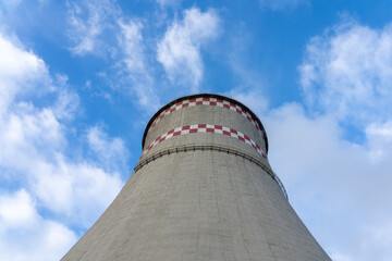 CHP pipe for cooling liquid after heating. A large chimney against the yearly sky.
