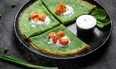 Green spinach crepes or pancakes with smoked salmon and soft cheese. banner, menu, recipe, place for text
