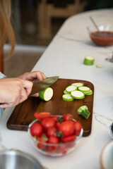Zucchini cutting. Woman chopping zucchini on cutting board