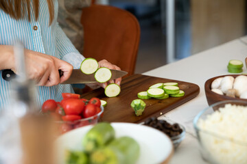 Obraz na płótnie Canvas Zucchini cutting. Woman chopping zucchini on cutting board