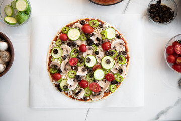 Woman adding healthy ingredients to pizza. Home made concept. top view.