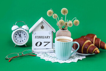 Calendar for February 7: a decorative house with the name of the month in English, the numbers 07,...