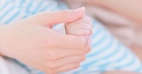 mom holds baby hand