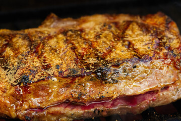 grilling steaks on flaming gas grill and shot with selective focus. Backyard grilling. rib-eye steaks cooking on flaming grill