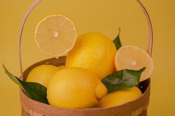 Yellow lemons in a wooden basket. Lemons in a basket. Foreground. horizontal composition.