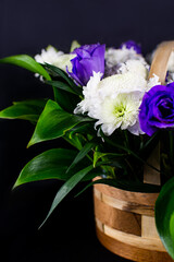Flowers in a basket. Roses in a basket. Present. Flowers are white and purple.