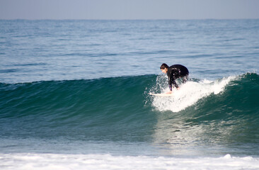 Happy teenager surfing in the Atlantic Ocean