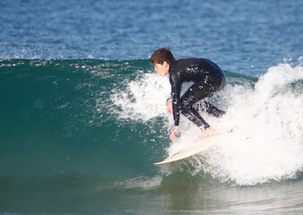 Happy teenager surfing in the Atlantic Ocean