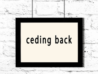 Black frame hanging on white brick wall with inscription ceding back - obrazy, fototapety, plakaty