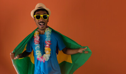 Black man in costume for carnival with brazil flag isolated on orange background. African man in various poses and expressions.