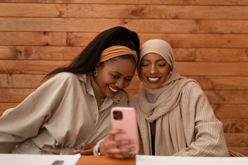 Two besties taking a selfie together in a restaurant