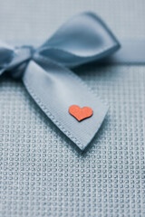 Blue silver gift box with bow and little red heart flatly. Gift given with love to boyfriend, girlfriend, husband, wife, mom, sweetheart lovers at Valentine's Day at February 14. I love you. Feelings.