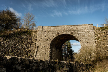 Fototapeta na wymiar old stone bridge under blue skies and clouds