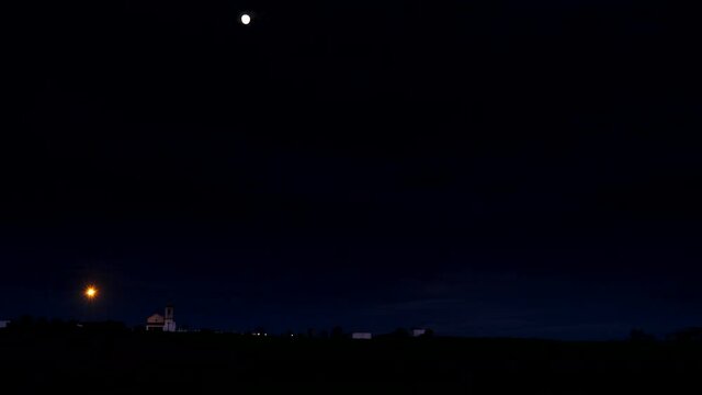 Time lapse of night is falling over village Luz with church Nossa Senhora, district of Evora, Portugal.