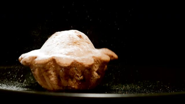 Fresh cupcake falls on a black plate